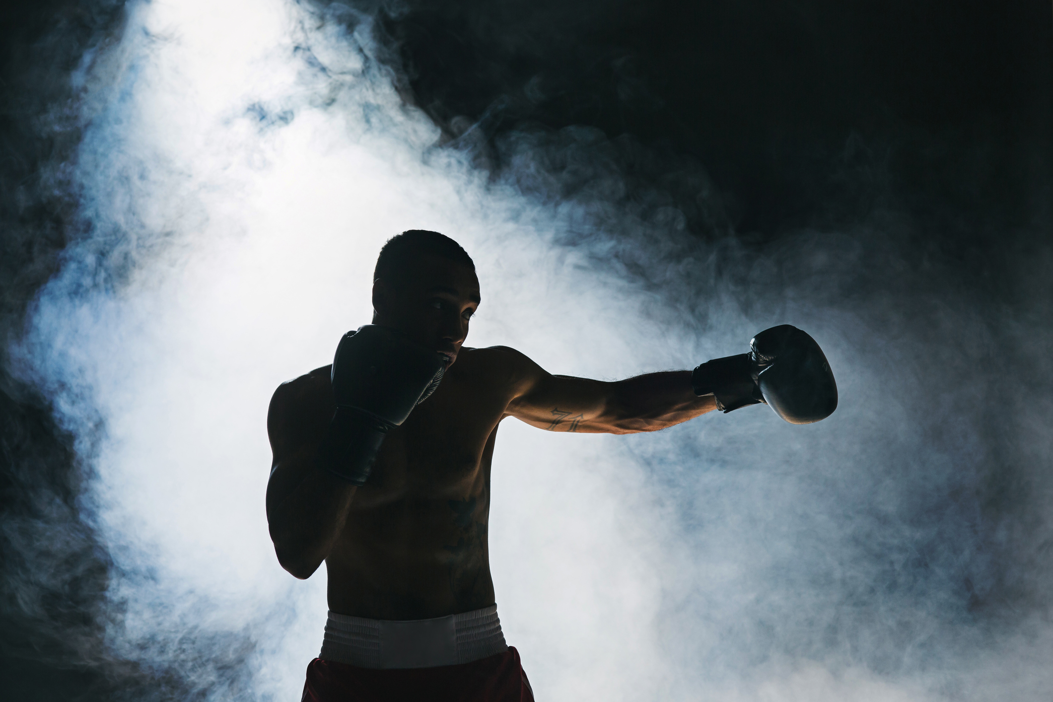 Afro american male boxer. Young man boxing workout in a fitness club. Muscular strong man on background black studio